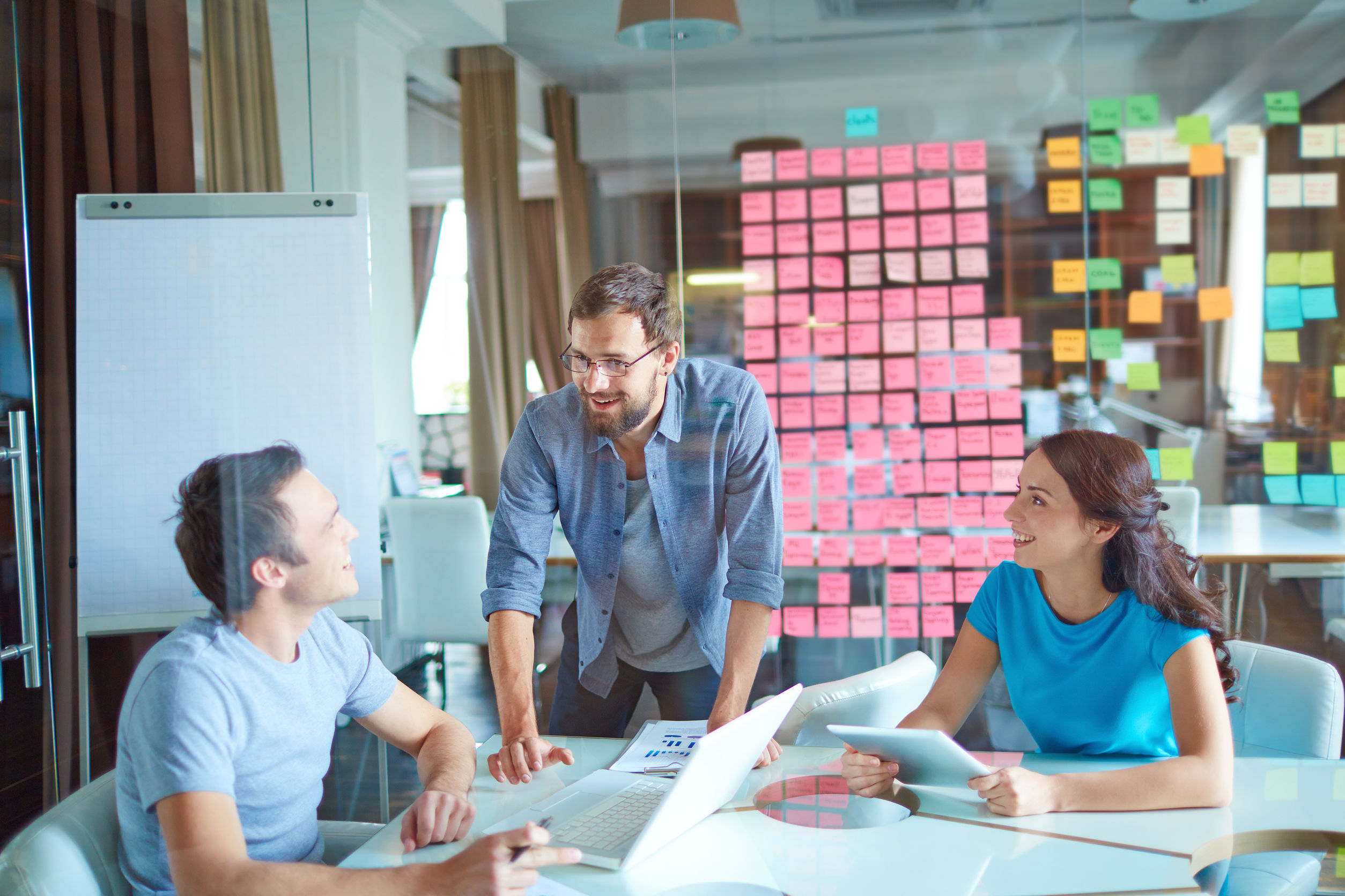 Group of three successful business partners in casual communicating at meeting in office Project manager